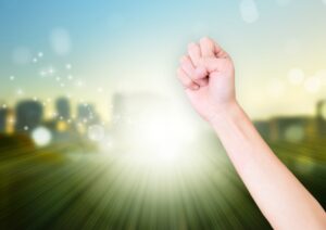 握りこぶしを空に向けて上げる