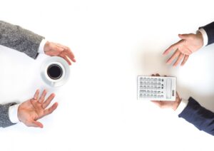 計算機とコーヒーがある打合せ風景